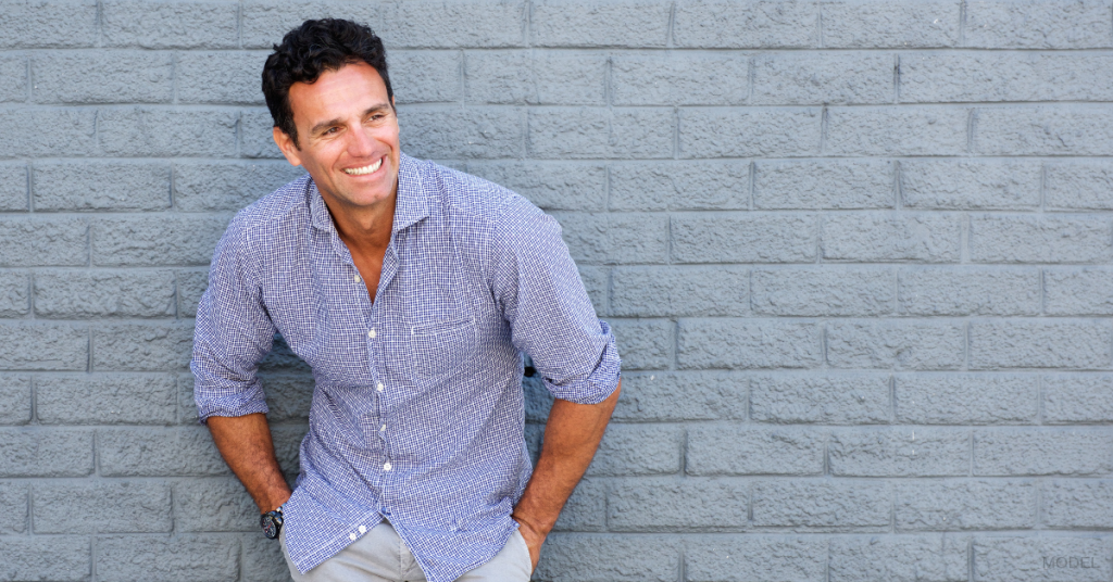 Attractive mature man leaning against a brick wall (model)