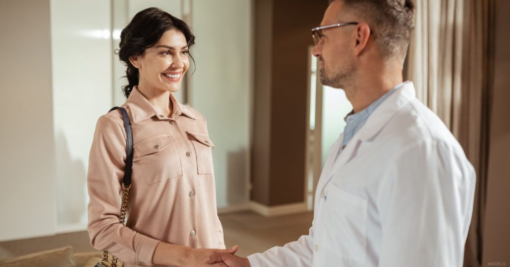 Woman is shaking hands with a plastic surgeon in a doctor's office (models)