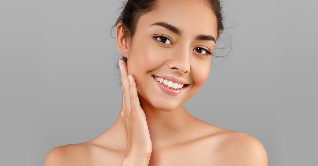 Model touching face after infini removed acne scars