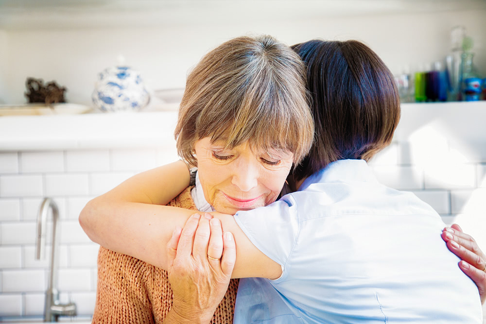 Woman hugging female alzheimer's patient