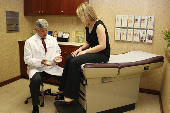 Dr. Parker sitting with patient and showing her breast implants