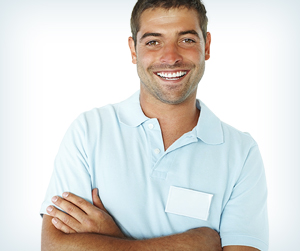 Young man wearing a light blue polo shirt, smiling with arms crossed