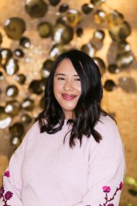 Rosa Ordaz wearing a light pink sweater with flowers embroidered on the sleeves