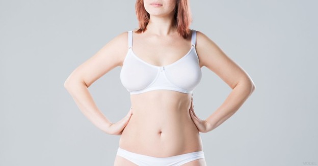 Woman in white lingerie with her hands on her waist (model)