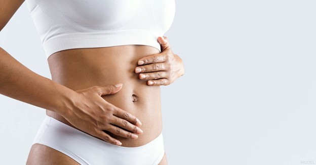Woman in white lingerie with her hands on her stomach (model) 
